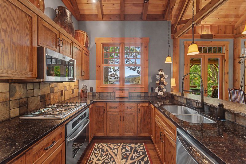 Kitchen gas range with a tile backsplash and window over the sink